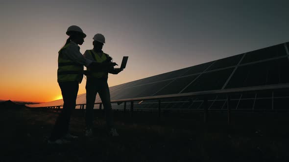 Two Power Engineers Are Arguing Next To Solar Batteries