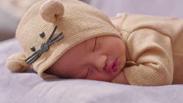 happy newborn baby weaing cute Mouse costume lying sleeps on a grey blanket comfortable