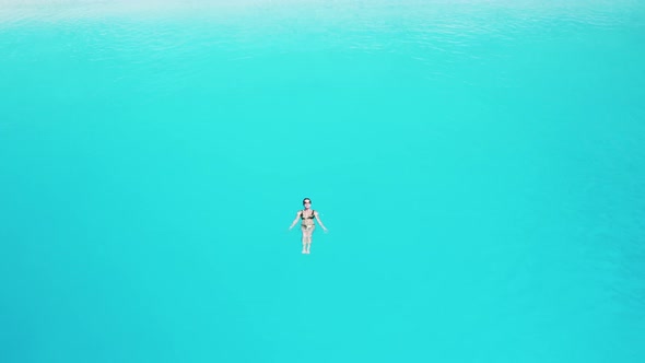 Drone view of woman swimming in blue sea.