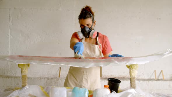 Woman making surfboard