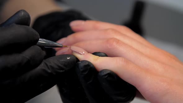 Experienced Manicurist Applies Layer of Gel on Fingernail