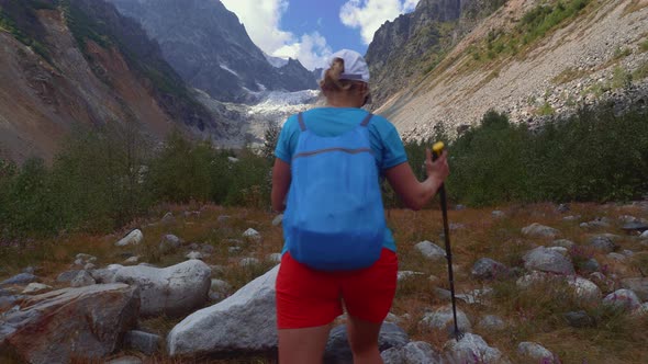 Tourist girl on a hike to the glacier in Caucasus mountains, Georgia