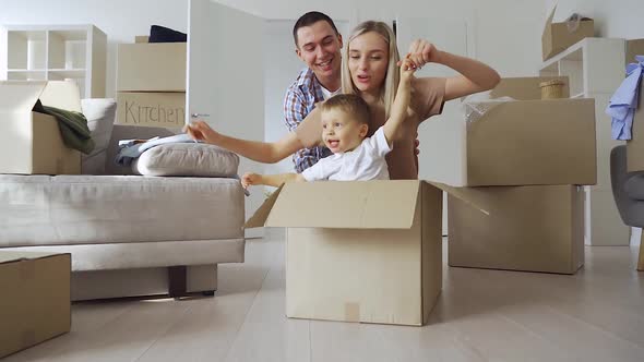 Happy Joyful Parents and Kid Ride Carton Box in New Mortgage Apartments