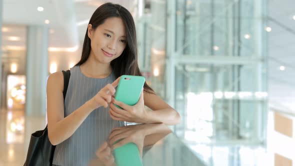 Woman using mobile phone in shopping mall