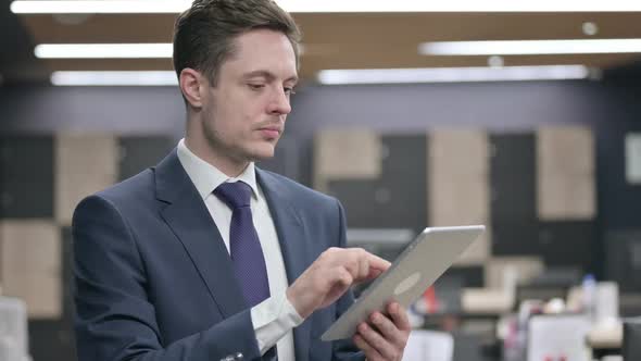 Businessman Using Tablet While Sitting in Office