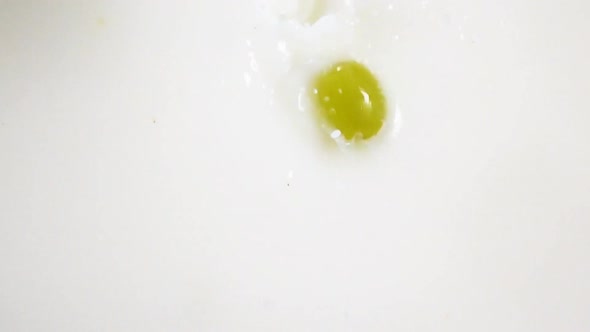 Green Berries of Grape Falling Down Into Milk