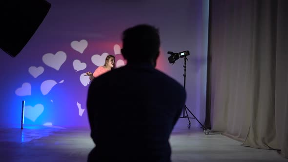 Unrecognizable Video Operator Shoots a Portrait of Two Girls Dancing in Neon Light