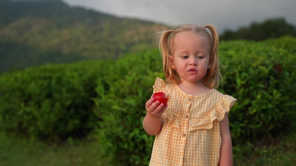 Baby Girl Eating Fruit Outdoors