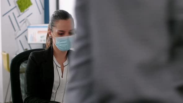 Business Woman with Protective Face Mask Analysing on Laptop Computer Marketing Statistics