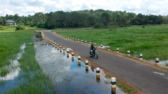 Motorbike rider on Indian village road,Bike Rider,Road between river,
