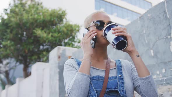 Mixed race woman on the phone drinking coffee