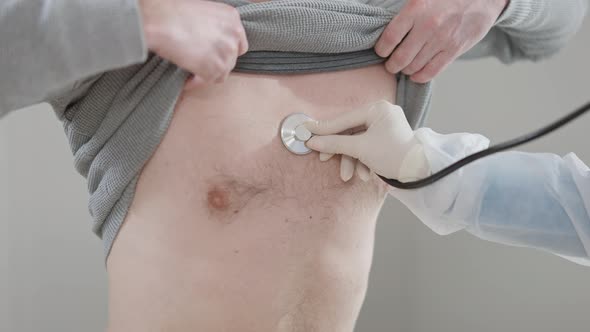 Closeup of Doctor Hand Performing Auscultation with Stethoscope Listening Internal Sounds of