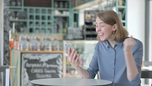 Successful Young Woman Celebrating on Smartphone