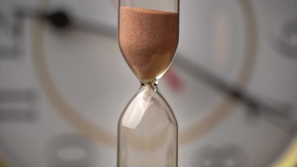 Hourglass Closeup is Pouring Against the Background Ordinary Mechanical Watch