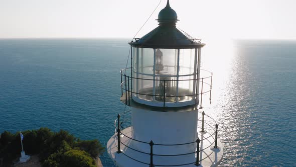 Close up drone view of lighthouse top against sunlight.