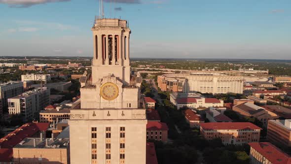 Slow aerial orbit of the UT tower with focus on the football stadium and eventually revealing downto
