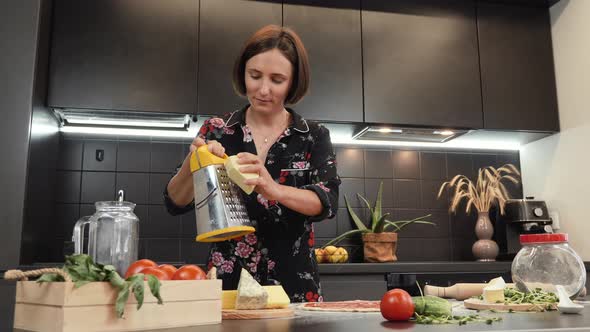 Woman grating hard cheese.