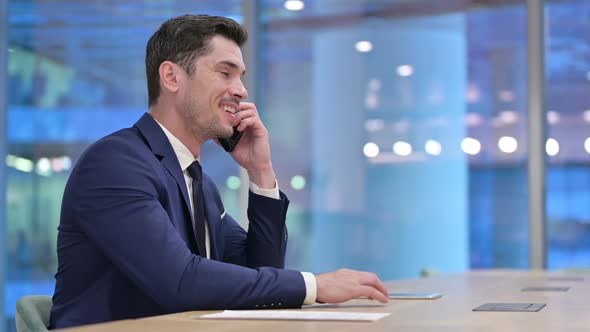 Businessman Talking on Smartphone in Office