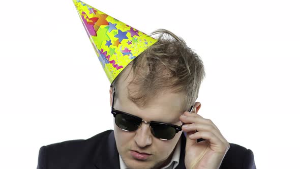 Drunk Sleepy Young Businessman with Hangover in Festive Cap Drink Alcohol Cognac