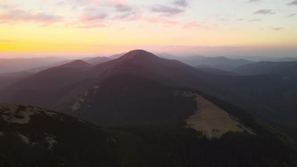 Aerial View of Bright Foggy Morning Over Dark Peak with Mountain Forest Trees at Autumn Sunrise