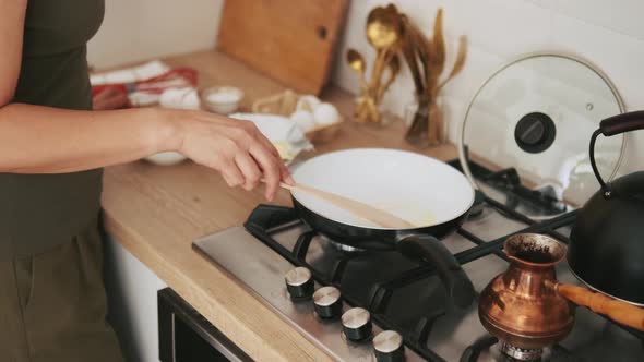 Woman spreading butter in a frying pan kitchen