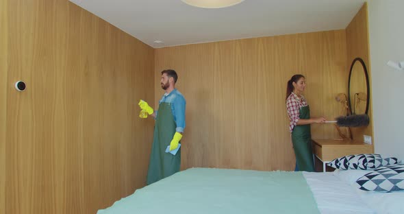 Couple As a Professional Cleaners in Uniform Rubbing Furniture and Wiping Dust in the Bedroom or