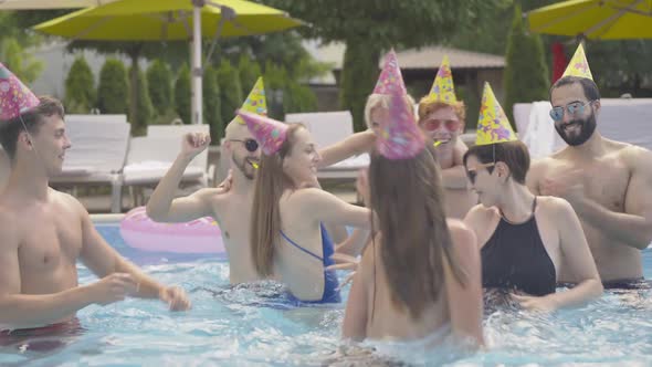 Young Multiracial Friends Dancing in Pool in Luxurious Resort on Sunny Summer Day. Portrait of