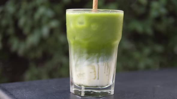 Side View of Glass with Matcha Tea and Soya Milk Layers Mixed Together