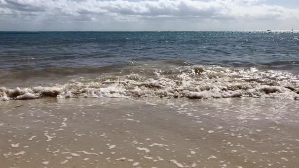 wave on a sand beach during a sunny day