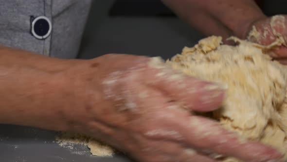Closeup of Kneading Dough on the Table Grandmother's Hands Knead Dough for Making a Delicious Dish