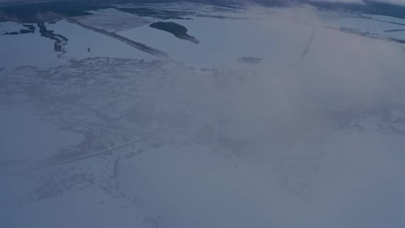 View of the Russian Village Through the Clouds in Winter at Dusk