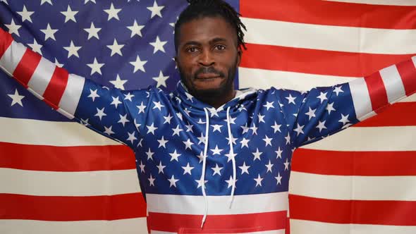 Happy African American Proud Man Holding American Flag in Stretched Hands Looking at Camera Smiling
