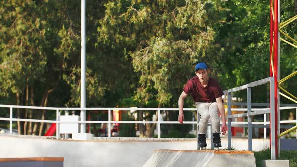 Aggressive Inline Roller Skater Doing Tricks in Concrete Skatepark Outdoors with Beautiful