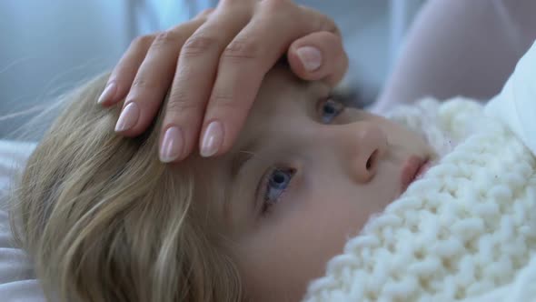 Mother Touching Sick Little Daughter Forehead, Checking Body Temperature Level