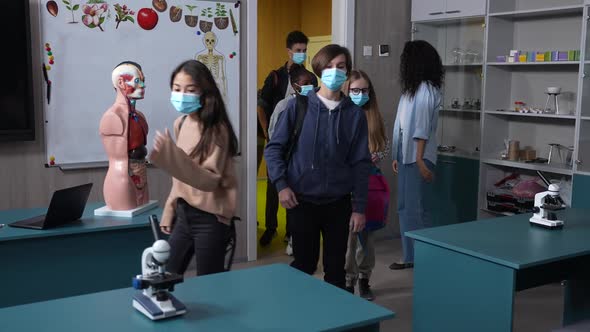 Masked Multinational Pupils Entering Classroom