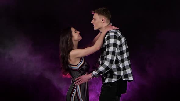 Guy Is Waiting for His Girlfriend, She Comes, He Turns Her Around. Multi Colored Smoke Background