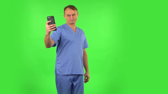 Medical Man Makes Selfie on Mobile Phone Then Looking Photos on Green Screen.