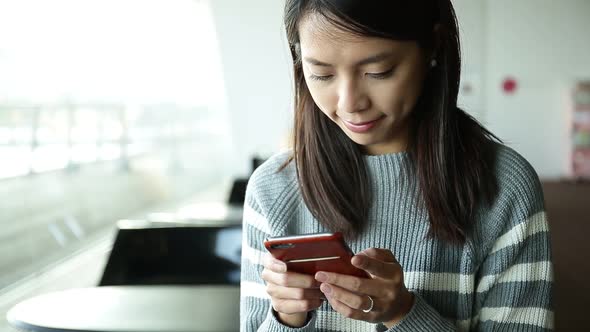 Woman look at the mobile phone at indoor cafe