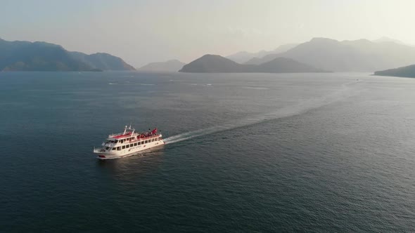 A Cruise Ship Sails in the Bay Against the Backdrop of Mountains or Fjord. Cruise Ship with Tourists