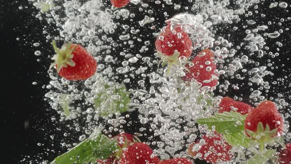 Strawberry Beautiful Falling Into Water in Slow Motion on Black Background