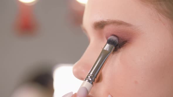 Work of a Makeup Artist. Applying Shadows To the Eyelid of the Model's Eye