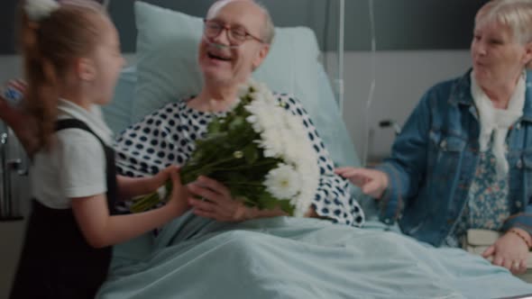 Close Up of Retired Man Receiving Visit From Niece and Daughter in Hospital Ward