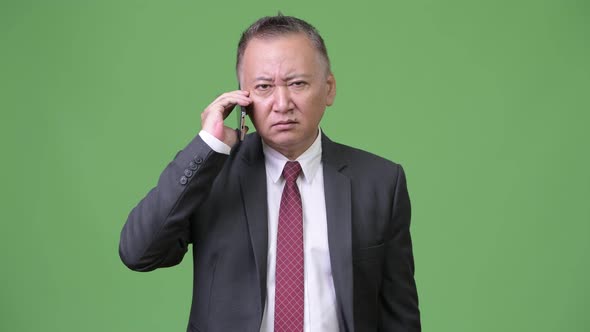 Mature Japanese Businessman Using Phone