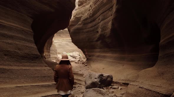 Woman walking inside in ravine with big stones"