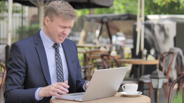 Businessman in Shock By Failure on Laptop Outdoor Cafe