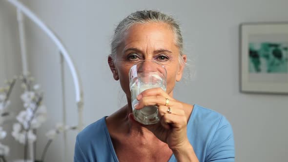 Mature woman drinking a glass of milk