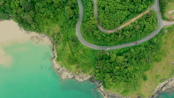 Aerial shot of beauty bay nature landscape with island, cars driving and clear sea with turquoise wa