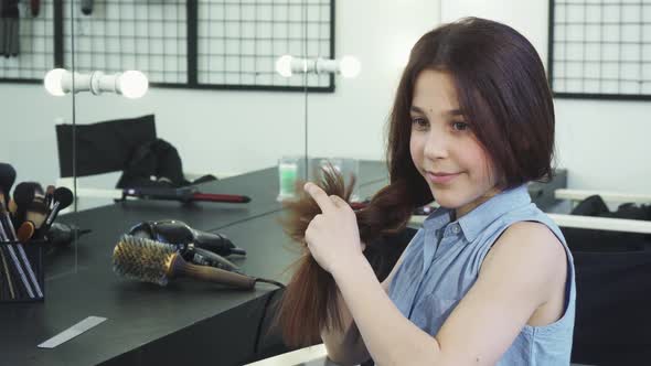 Cute Happy Girl Braiding Her Hair Smiling To the Camera