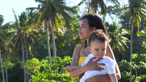 Mother and Baby Standing Outdoor in Front of Beach Enjoying the Fresh Air