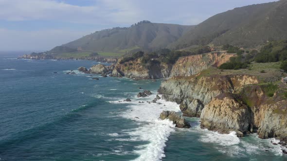 Forward Aerial Pan of Waves Crashing on the Rocky Shores of Big Sur California